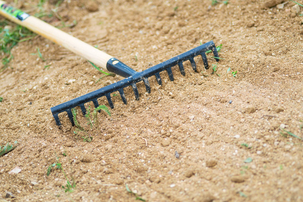 Working In Garden With Rake Leveling Ground. Work In Garden With Rake. Preparation Of Ground For Seeding and Planting. - Photo, Image