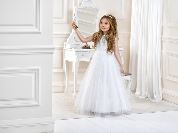 Muotokuva söpö pieni tyttö valkoinen mekko ja seppele ensimmäinen pyhä ehtoollinen tausta kirkon portti - Kuva. Nuori mallivalkoinen ehtoollinen mekko seisoo tyylikäs palatsi
 - Valokuva, kuva
