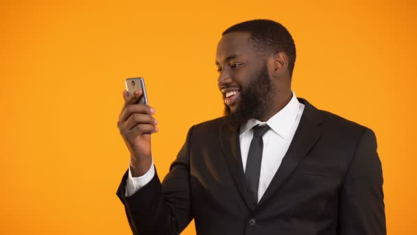 Satisfied with mobile application performance black male showing thumbs-up - Séquence, vidéo