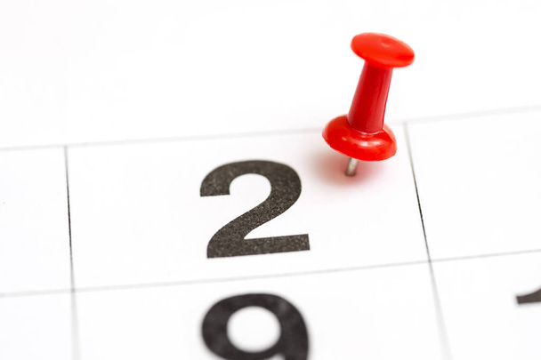 PIN op de datum nummer 2. De tweede dag van de maand is gemarkeerd met een rode Thumbtack. PIN op kalender - Foto, afbeelding