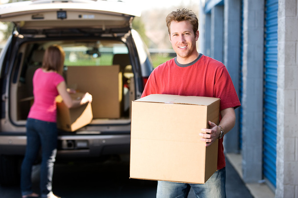 Storage: Man Holding Box with Woman Behind - Foto, imagen