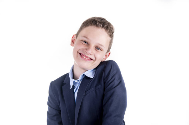 Αγόρι σε ένα μπλε πουκάμισο και ένα σακάκι χαμόγελα φιλικό στην κάμερα - Φωτογραφία, εικόνα