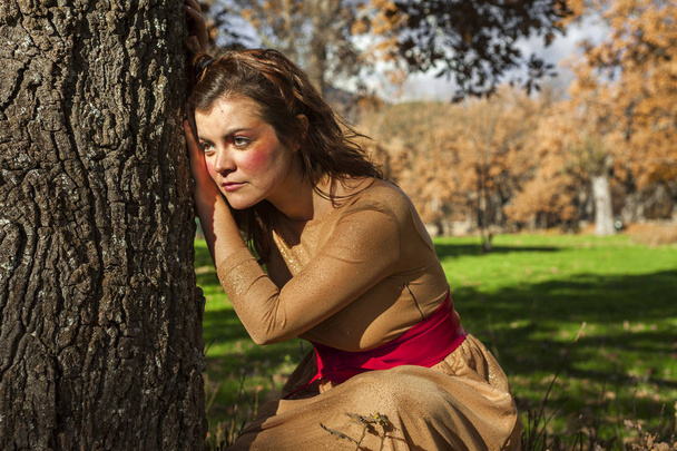 Medium shot portrait elegant young woman standing in a tree. Loo - Foto, Imagen