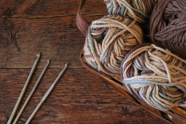 Uma imagem de perto de fios de crochê e ganchos de crochê em uma mesa de madeira vintage
.  - Foto, Imagem