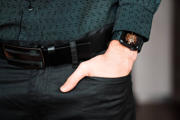 Young businessman wearing a smart watch, holding his hand in a pocket. - Fotografie, Obrázek