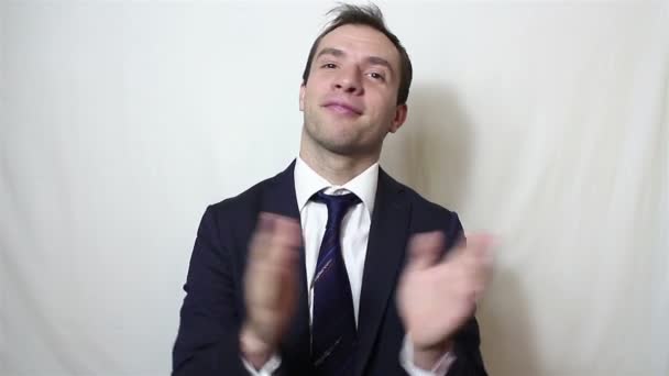 Handsome young businessman smiling and actively clapping hands, greeting new customers - Séquence, vidéo