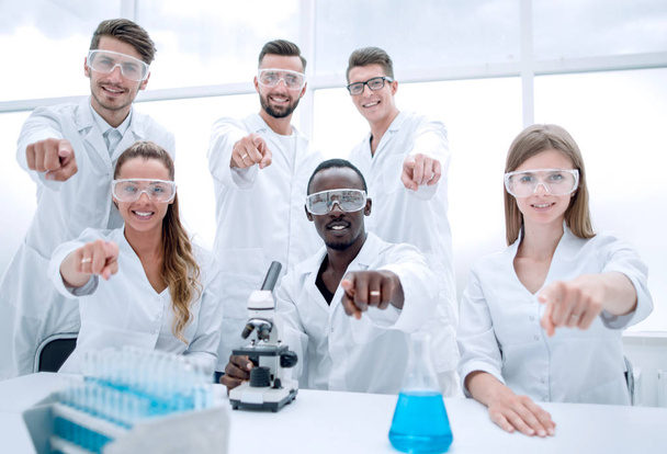 Group of young successful scientists posing for camera - Foto, afbeelding