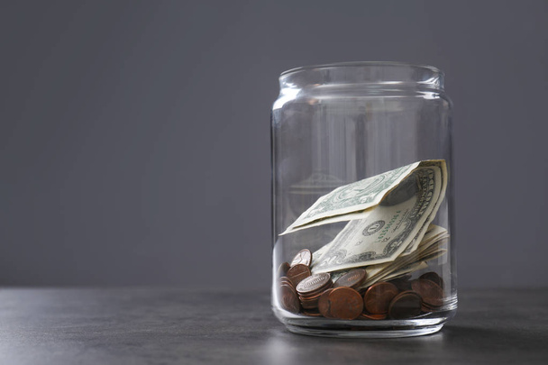 Donation jar with money on table against grey background. Space for text - Photo, Image