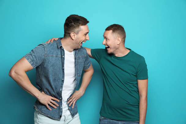 Man laughing with his friend against color background - Photo, Image