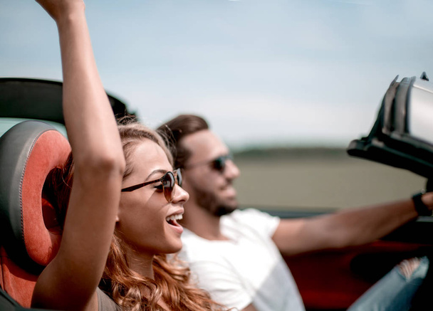 close up.a young woman with her boyfriend in a convertible car - Фото, изображение