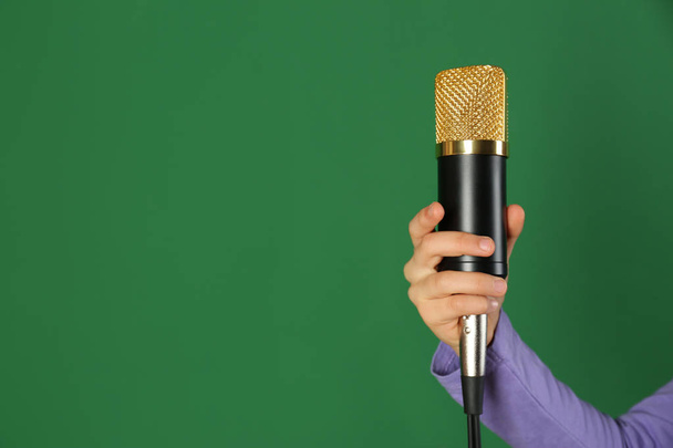 Child holding microphone on color background, closeup. Space for text - Zdjęcie, obraz