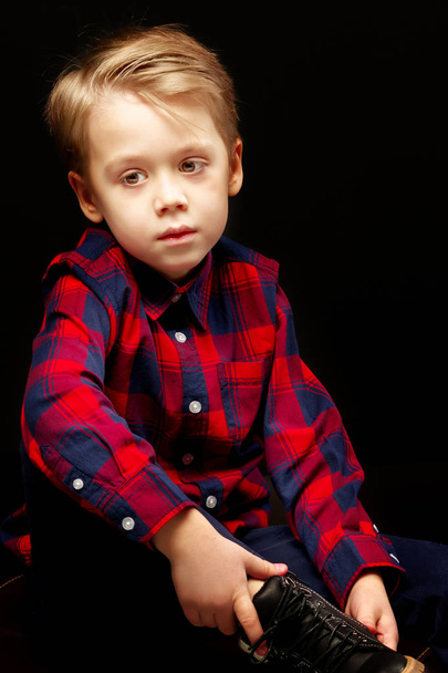 Beautiful little boy on a black background, close-up. - Fotó, kép