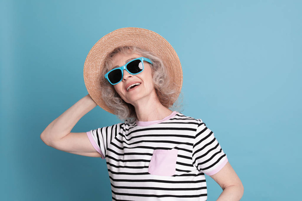 Portrait of mature woman in hipster outfit on color background - Φωτογραφία, εικόνα
