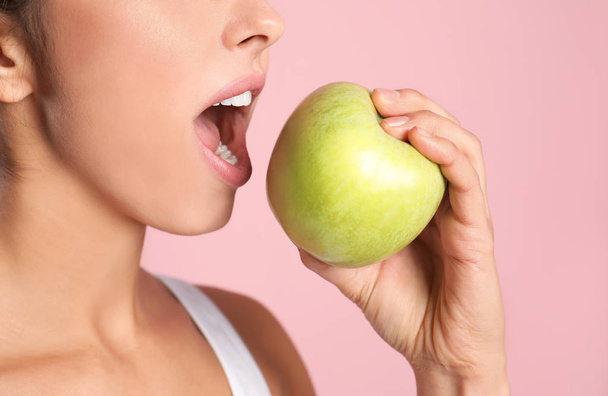 Young woman with healthy teeth and apple on color background, closeup - Fotografie, Obrázek