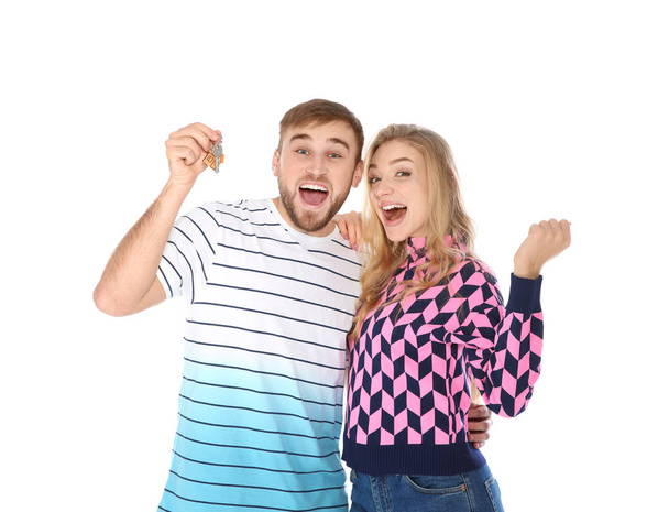 Happy young couple with house key on white background - Foto, afbeelding