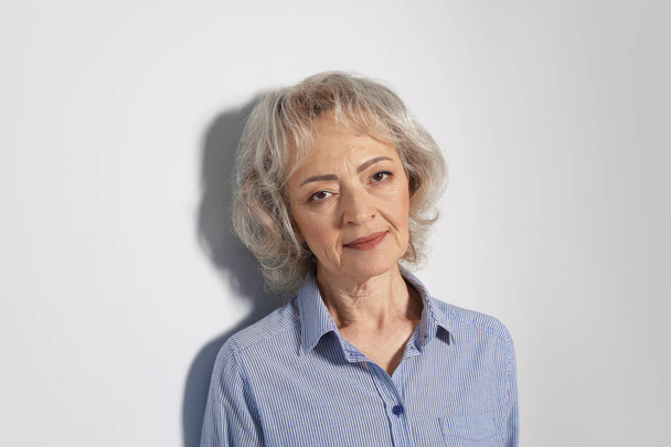 Portrait of mature woman on grey background - Фото, зображення
