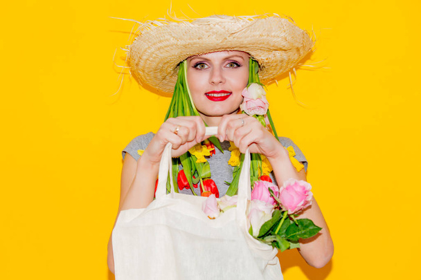 Frau mit Hut und Tulpen im Haar hält Einkaufstasche  - Foto, Bild