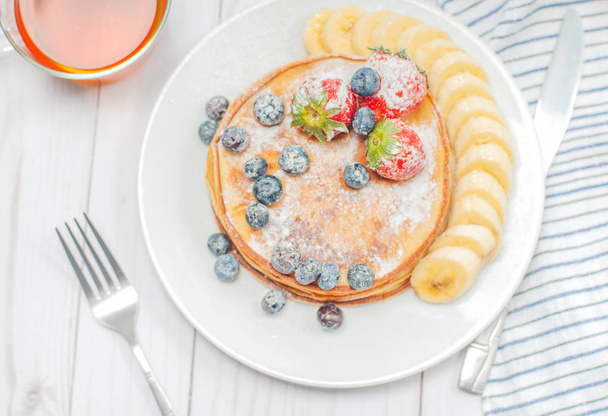 Healthy breakfast, black tea and homemade pancakes with fresh be - Fotografie, Obrázek