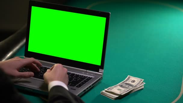 Člověk pomocí přenosného počítače na pokerovém stole, vydělávat peníze v online sázení, sázení - Záběry, video