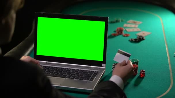 Man paying poker bet with credit card, using laptop green screen, online winning - Metraje, vídeo