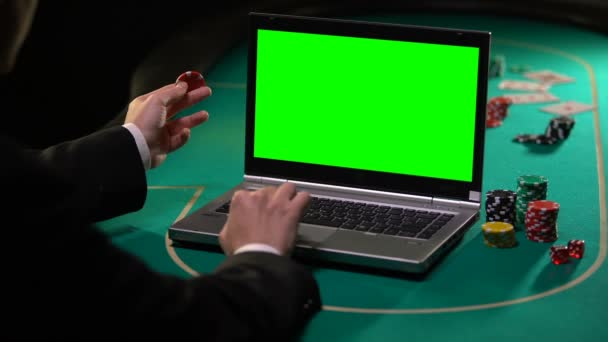 Man holding lucky chip and betting on gambling services on laptop, green screen - Filmmaterial, Video