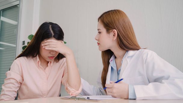Orvos beszél a boldogtalan tizenéves beteg vizsga szoba. Ázsiai nő orvos ösztönzése és támogatása a rákos beteg, miután consult, és megvizsgálja az egészségügyi orvosi klinika, vagy kórházi. - Fotó, kép
