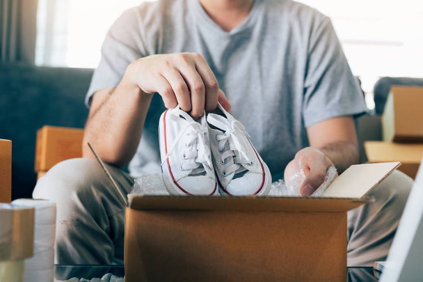 Asiático empresario adolescente está llevando zapatos de bebé y poner en un
  - Foto, Imagen