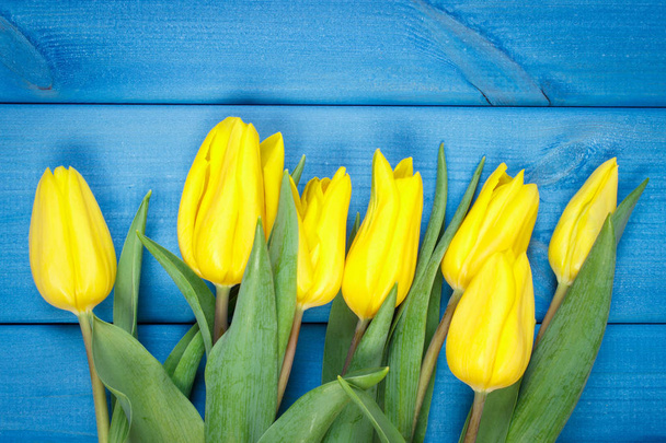 Bouquet of fresh tulips on blue wooden background - Fotoğraf, Görsel