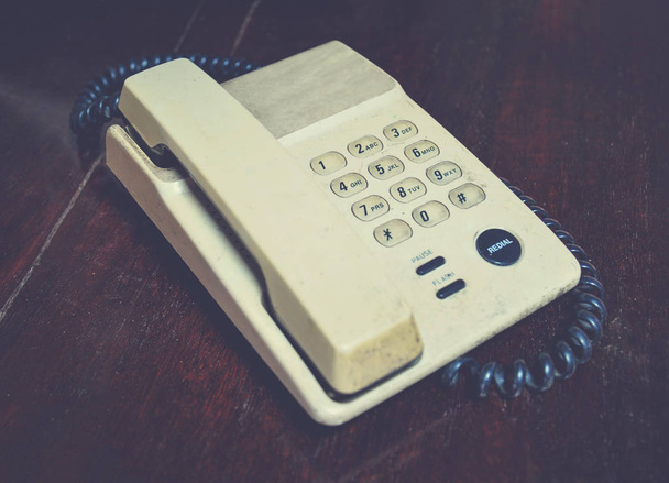 Ретро телефон старый на деревянном столе в офисе старинный стиль тона
 - Фото, изображение