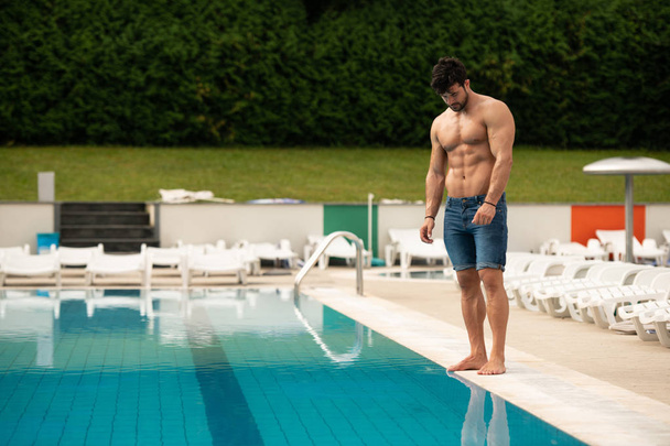 Mladá Macho muž při pohledu na plavecký venkovní bazén - Fotografie, Obrázek