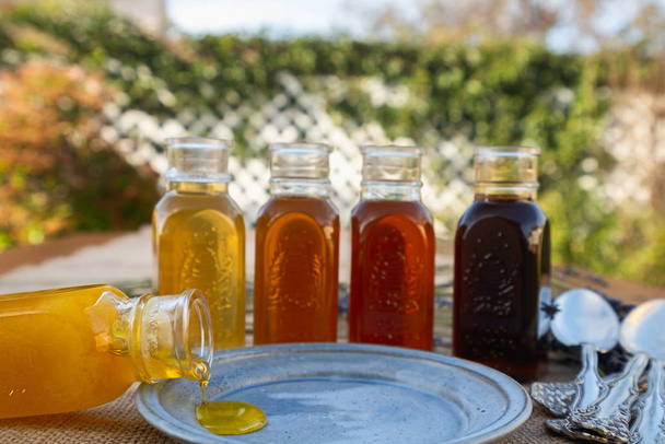 Surtido de miel en botellas de fondo natural
 - Foto, imagen