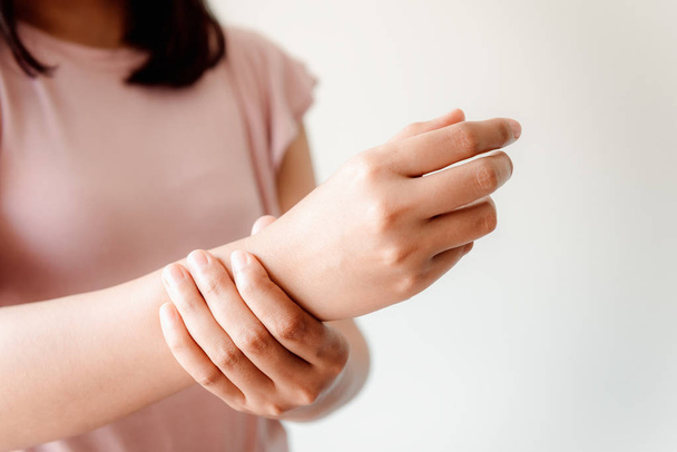 Nahaufnahme der Frauenhand massiert ihre Handgelenkschmerzen bei den Hausaufgaben - Foto, Bild