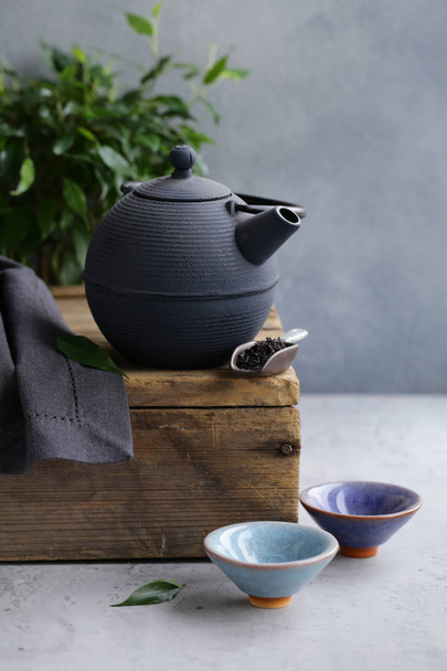 cast iron kettle on wooden table for tea ceremony - Foto, afbeelding