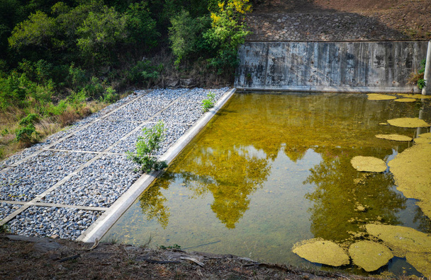 Reservatório de barragem de drenagem na colina com canal e sistema de drenagem wa
 - Foto, Imagem