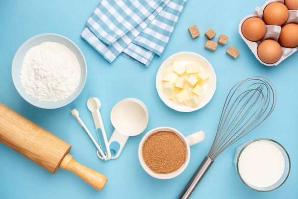 Kitchen utensils and baking ingredients on blue background - Foto, Bild