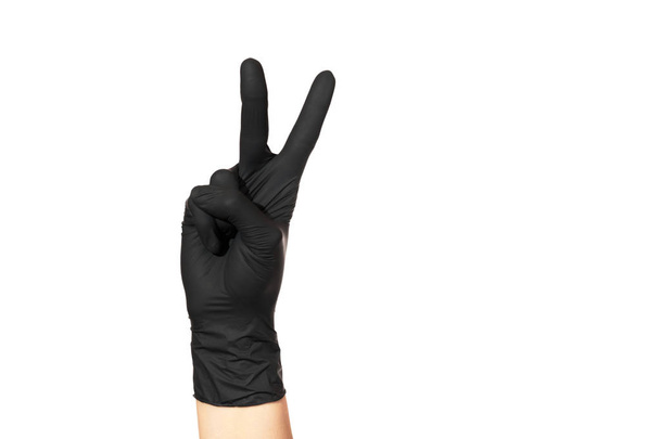 Female hand in black glove on white background with two fingers raised up - Foto, imagen