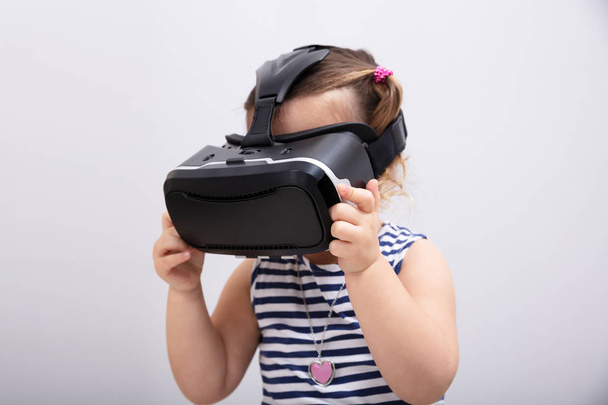 Small Girl Using The Virtual Reality Headset On White Background - Photo, Image