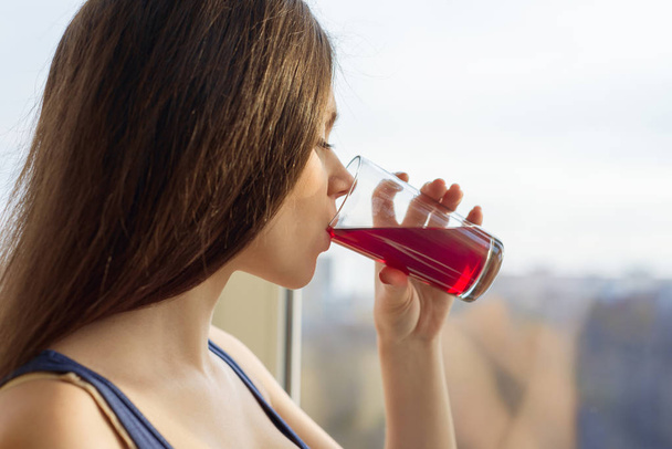 Mujer joven bebiendo jugo natural de bayas frescas de un vaso, primer plano - Foto, imagen