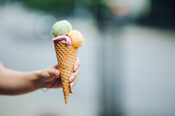 Mujer sosteniendo delicioso helado colorido. Vibraciones de verano y comida dulce
. - Foto, imagen