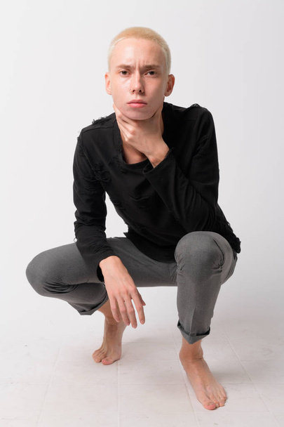 Full body shot of young androgynous man crouching - Photo, Image