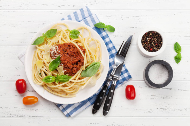 Спагетти-болоньезе с помидорами и мясным соусом, сыром пармезан и свежим базиликом
 - Фото, изображение