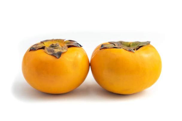 Persimmon is a yellow fruit. has the scientific name of Diospyros kaki. isolated on white background and clipping path. - Photo, Image