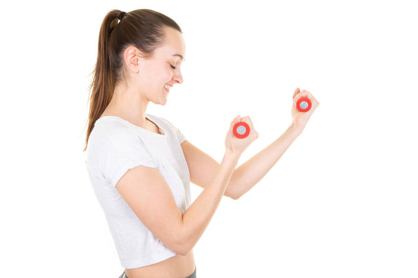 zijkant profiel weergave jonge sport vrouw maken oefeningen met halters - Foto, afbeelding