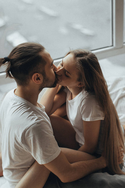   beautiful loving couple kissing in bed - Фото, изображение