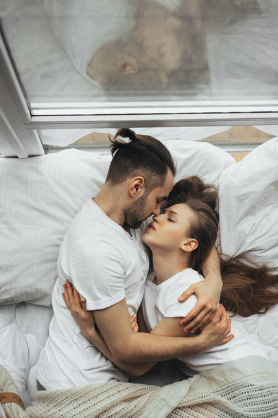   beautiful loving couple kissing in bed - Photo, Image