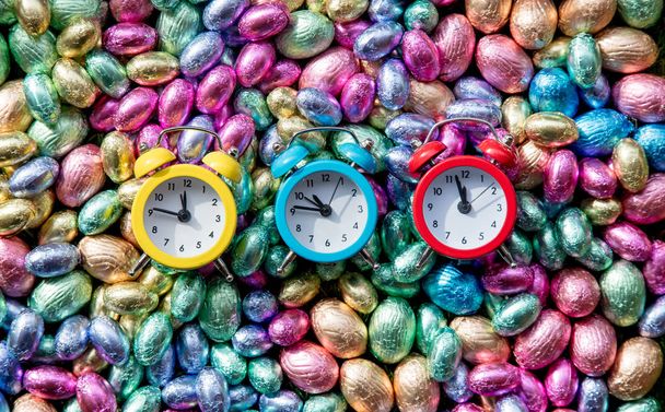 väri Suklaa pääsiäismunat ja kolme herätyskelloa
 - Valokuva, kuva