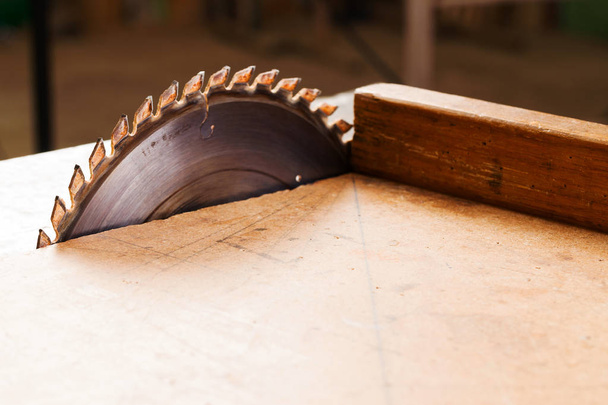Ferramentas de carpinteiro em mesa de madeira com serragem. Serra Circular. Corte de uma prancha de madeira
 - Foto, Imagem