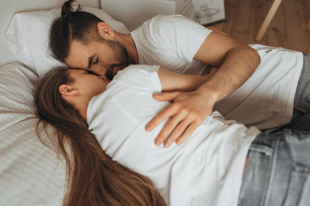 schönes liebevolles Paar küsst sich im Bett - Foto, Bild