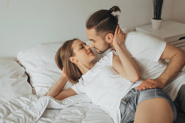 Beautiful loving couple kissing in bed - Fotografie, Obrázek