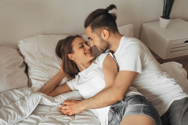 Beautiful loving couple kissing in bed - 写真・画像